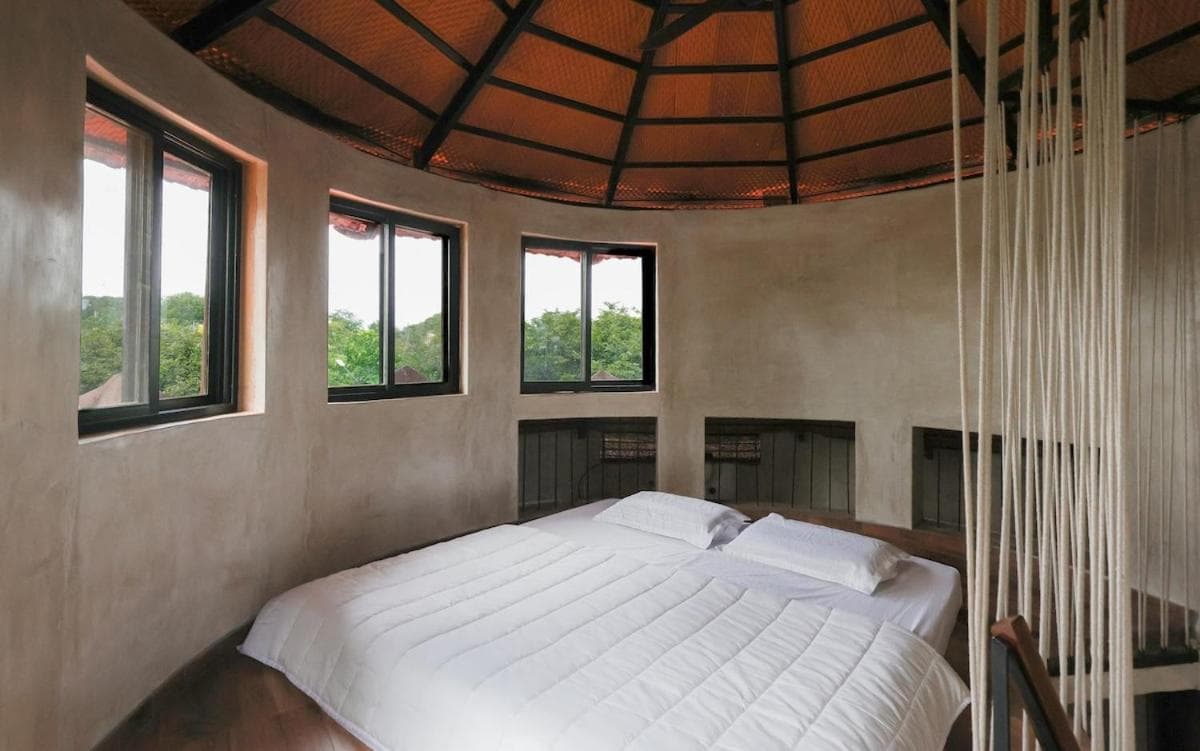 The round bedroom with its deep-set windows and crisp white bedding